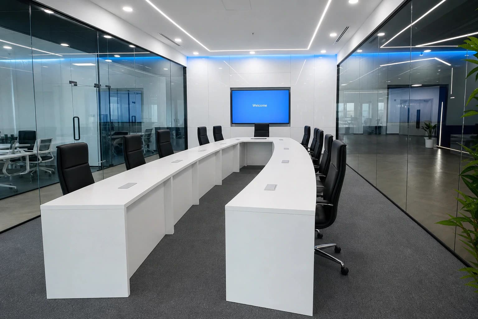 Glass-walled meeting room with U-shaped table for small-group coaching
